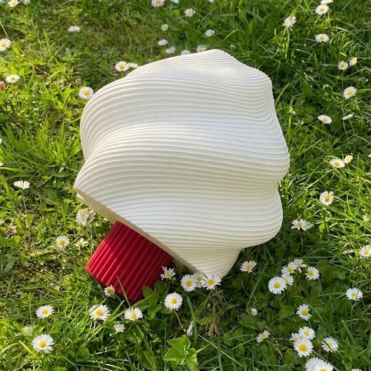 White fire hose coiled on grass with daisies